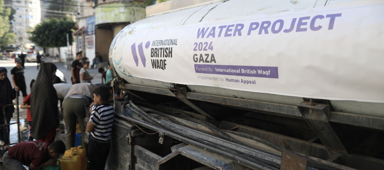 Water tanker labeled 'Water Project 2024 Gaza' with people filling containers on a street.