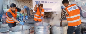 sadaqah in ramadan hadith Volunteers in orange vests stir large pots of food at a humanitarian hot meals project.