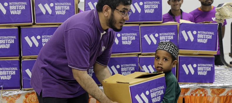 A man giving a small child a box of food for his family