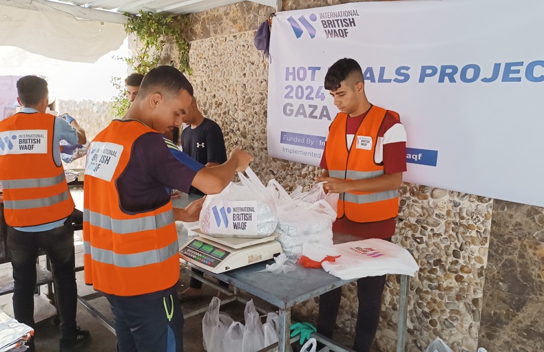 Best Form Of Sadaqah Jariyah Volunteers in orange vests pack and distribute food bags as part of a humanitarian hot meals