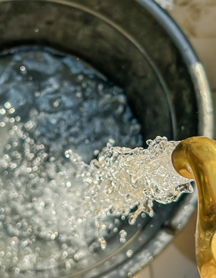 A faucet that pours water into a bucket